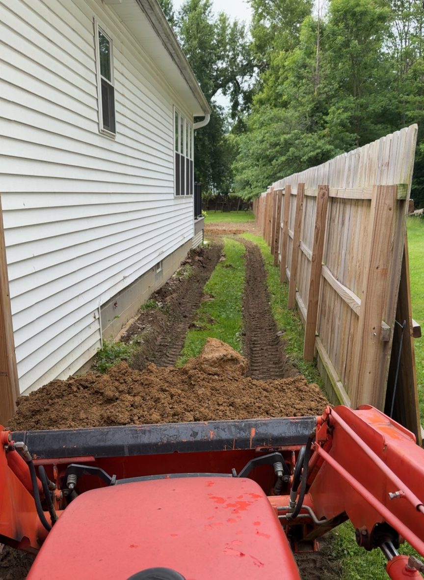 FP Projects tractor regrading a side yard between a house and fence